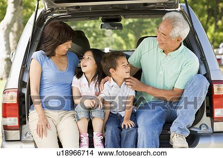 Picture - Grandparents with grandkids in tailgate of car. Fotosearch