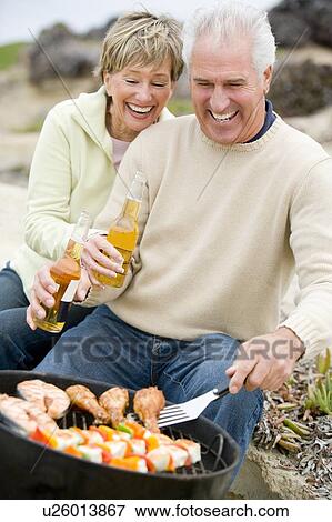 Stock Photo - Couple Cooking On A Barbeque. Fotosearch