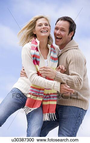 Couple standing outdoors smiling View Large Photo Image Stock Image - Couple standing outdoors smiling. Fotosearch