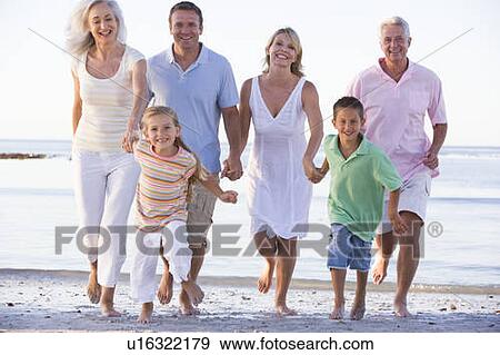Stock Photo - Extended family walking on beach. Fotosearch