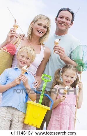 Stock Photo - Family at beach with ice cream cones smiling. Fotosearch