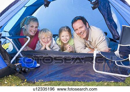 Stock Photograph - Family camping in tent smiling. Fotosearch