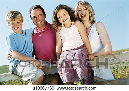 Stock Photo - Family on fence outdoors smiling. Fotosearch