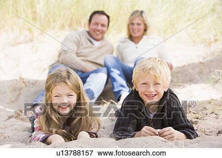 Stock Photo - Family relaxing on beach smiling. Fotosearch