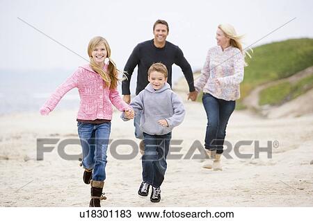 Family running at beach holding hands smiling View Large Photo Image Stock Image - Family running at beach holding hands smiling. Fotosearch