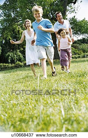 Family running outdoors smiling View Large Photo Image Stock Photo - Family running outdoors smiling. Fotosearch