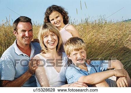 Stock Photo - Family sitting outdoors smiling. Fotosearch