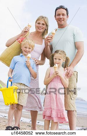 Family standing at beach with ice cream smiling View Large Photo Image Stock Image - Family standing at beach with ice cream smiling. Fotosearch