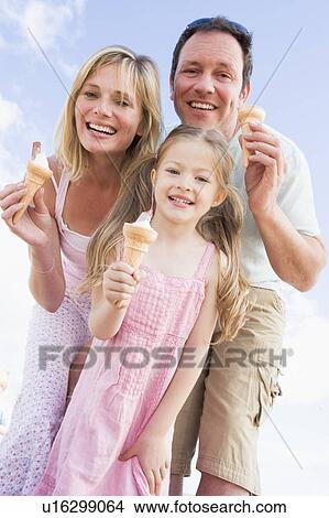 Family standing outdoors with ice cream smiling View Large Photo Image Picture - Family standing outdoors with ice cream smiling. Fotosearch