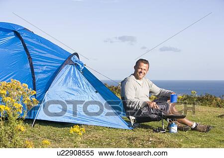 Man camping outdoors and cooking View Large Photo Image Stock Photography - Man camping outdoors and cooking. Fotosearch