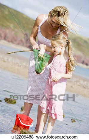 Mother and daughter at beach fishing and smiling View Large Photo Image Stock Photo - Mother and daughter at beach fishing and smiling. Fotosearch