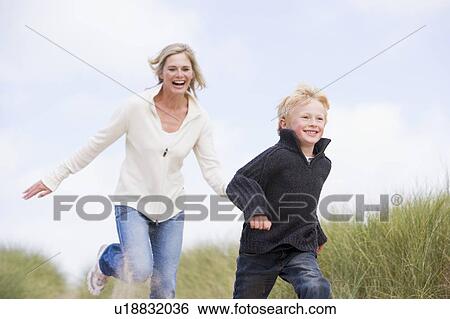 Mother and son running on beach smiling View Large Photo Image Stock Photograph - Mother and son running on beach smiling. Fotosearch