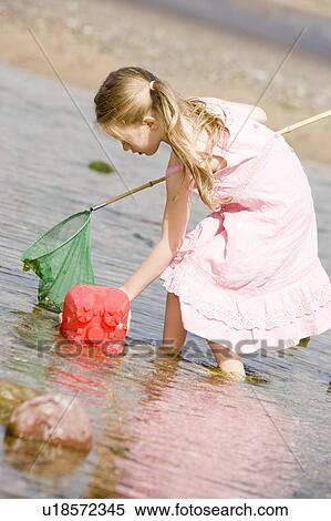 Young girl at beach with net and pail View Large Photo Image Stock Photography - Young girl at beach with net and pail. Fotosearch