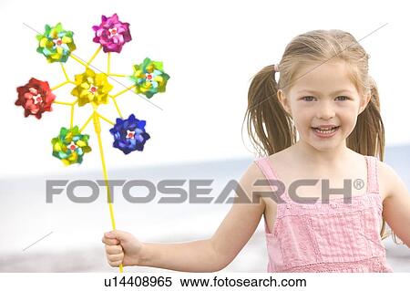Young girl at beach with toy windmill smiling View Large Photo Image Stock Photography - Young girl at beach with toy windmill smiling. Fotosearch