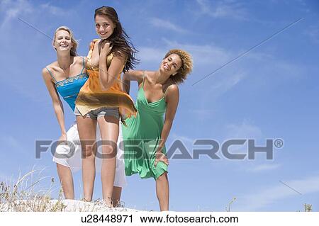 Stock Image - Young woman posing on a sand hill. Fotosearch