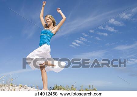 Stock Photo - Young woman posing on a sand hill. Fotosearch