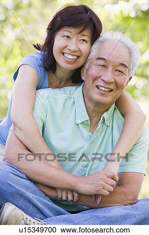 Couple relaxing outdoors in park smiling View Large Photo Image Stock Image - Couple relaxing outdoors in park smiling. Fotosearch