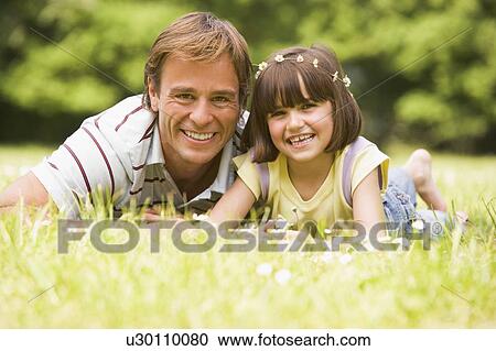 Father and daughter lying outdoors with flowers smiling View Large Photo Image Stock Image - Father and daughter lying outdoors with flowers smiling. Fotosearch