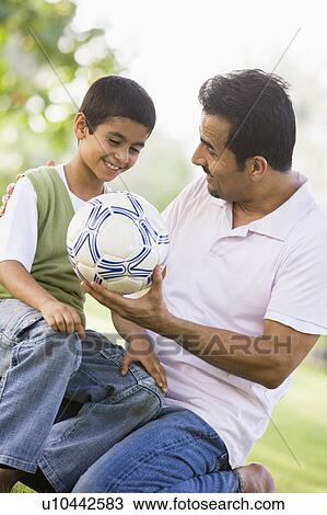 Father and son outdoors in park with ball smiling (selective focus) View Large Photo Image Stock Image - Father and son outdoors in park with ball smiling (selective focus). Fotosearch