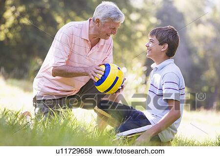 Grandfather and grandson at a park with a ball smiling View Large Photo Image Stock Photo - Grandfather and grandson at a park with a ball smiling. Fotosearch