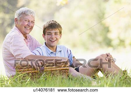 Stock Image - Grandfather and grandson at a picnic smiling. Fotosearch