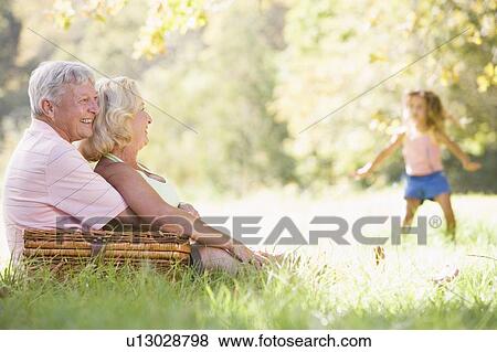 Grandparents at a picnic with young girl in background dancing View Large Photo Image Stock Photo - Grandparents at a picnic with young girl in background dancing. Fotosearch