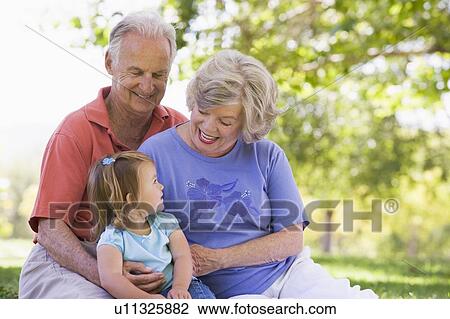 Grandparents with granddaughter in park View Large Photo Image Stock Image - Grandparents with granddaughter in park. Fotosearch