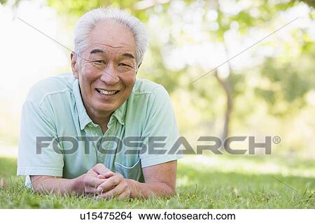 Man relaxing outdoors smiling View Large Photo Image Picture - Man relaxing outdoors smiling. Fotosearch