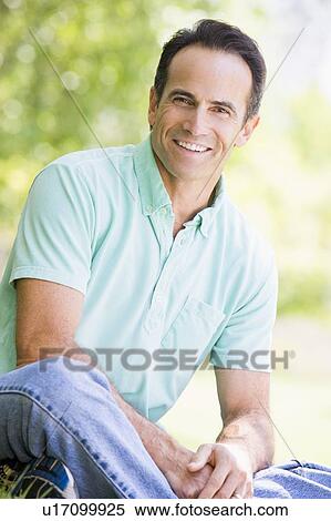 Man sitting outdoors smiling View Large Photo Image Stock Photography - Man sitting outdoors smiling. Fotosearch