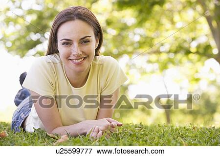 Stock Photo - Woman lying outdoors smiling. Fotosearch