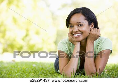Stock Photo - Woman lying outdoors smiling. Fotosearch