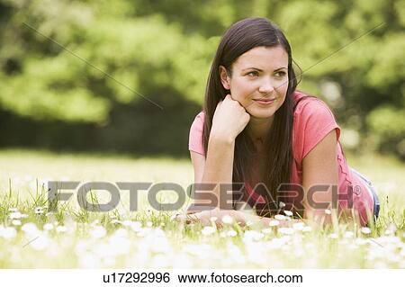 Stock Photograph - Woman lying outdoors smiling. Fotosearch