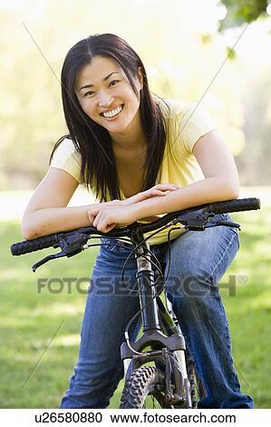 Woman on bicycle smiling View Large Photo Image Stock Image - Woman on bicycle smiling. Fotosearch