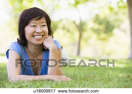 Stock Photo - Woman relaxing outdoors smiling. Fotosearch