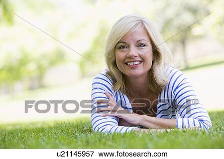 Woman relaxing outdoors smiling View Large Photo Image Stock Photo - Woman relaxing outdoors smiling. Fotosearch