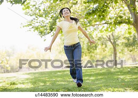 Woman running outdoors smiling View Large Photo Image Stock Image - Woman running outdoors smiling. Fotosearch
