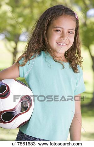 Young girl holding soccer ball outdoors smiling View Large Photo Image Stock Image - Young girl holding soccer ball outdoors smiling. Fotosearch