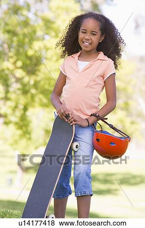 Young girl with skateboard outdoors smiling View Large Photo Image Stock Photo - Young girl with skateboard outdoors smiling. Fotosearch