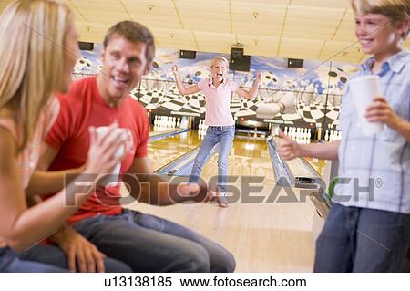 Family in bowling alley cheering and smiling View Large Photo Image Stock Photography - Family in bowling alley cheering and smiling. Fotosearch