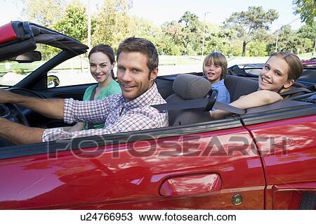 Stock Image - Family in convertible car smiling. Fotosearch