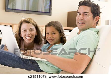Family in living room with laptop smiling View Large Photo Image Stock Photo - Family in living room with laptop smiling. Fotosearch