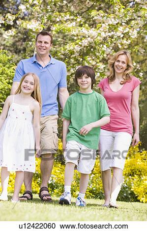 Stock Image - Family walking outdoors smiling. Fotosearch