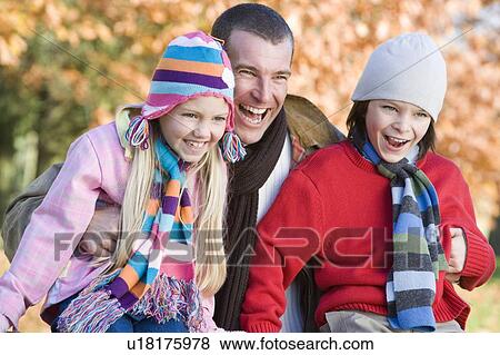 Father and two young children outdoors in park laughing (selective focus) View Large Photo Image Stock Photo - Father and two young children outdoors in park laughing (selective focus). Fotosearch