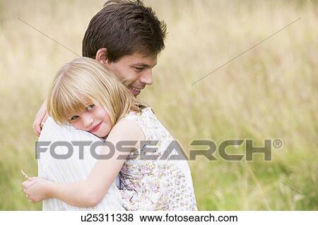 Father holding daughter outdoors smiling View Large Photo Image Stock Photo - Father holding daughter outdoors smiling. Fotosearch