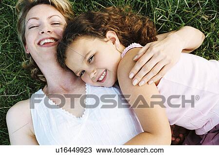 Mother and daughter lying outdoors smiling View Large Photo Image Stock Image - Mother and daughter lying outdoors smiling. Fotosearch