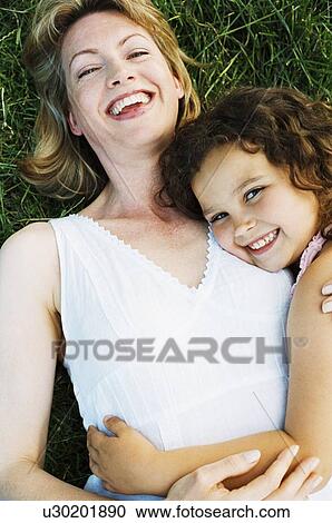 Mother and daughter lying outdoors smiling View Large Photo Image Stock Image - Mother and daughter lying outdoors smiling. Fotosearch