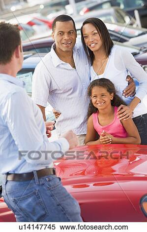 Mother and father with young daughter shopping for a new car View Large Photo Image Stock Photography - Mother and father with young daughter shopping for a new car. Fotosearch