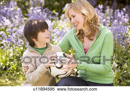 Mother and son outdoors holding ball smiling View Large Photo Image Stock Photography - Mother and son outdoors holding ball smiling. Fotosearch