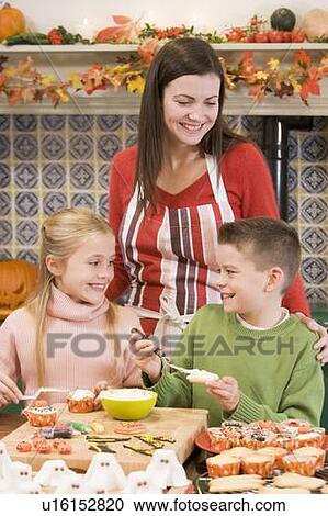 Mother and two children at Halloween making treats and smiling View Large Photo Image Stock Image - Mother and two children at Halloween making treats and smiling. Fotosearch