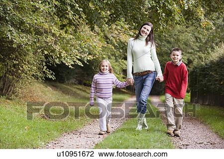 Mother and two children walking on path outdoors smiling (selective focus) View Large Photo Image Stock Image - Mother and two children walking on path outdoors smiling (selective focus). Fotosearch